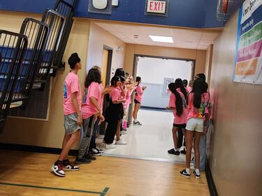 WEB program leaders line up to welcome new students through the gym doors.