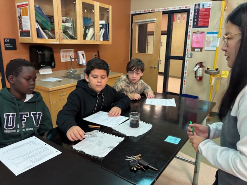 Grade 6 students performing a science experiment: will ice melt in water or pop faster?